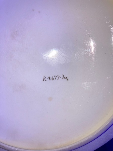 Handwritten characters on the bottom of a casserole dish.