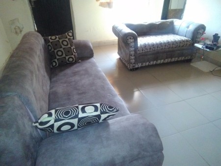 A brown couch with black and white throw pillows.