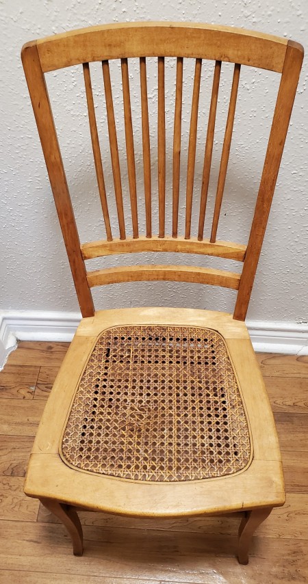 An old wooden chair with a wicker seat.
