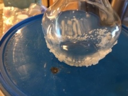 Dipping the bottle into bath salts.