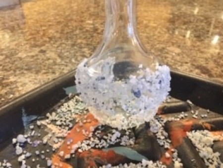 The bottle covered in bath salts halfway up.