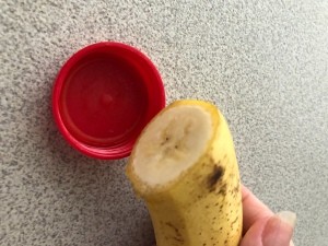 A cut banana next to a lid to fit.