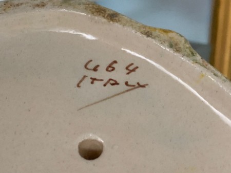 The markings on the underside of the figurine.