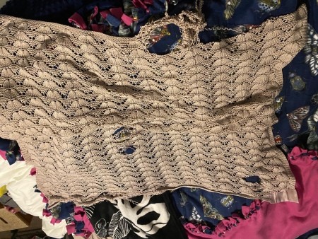 A worn knitted baby blanket.