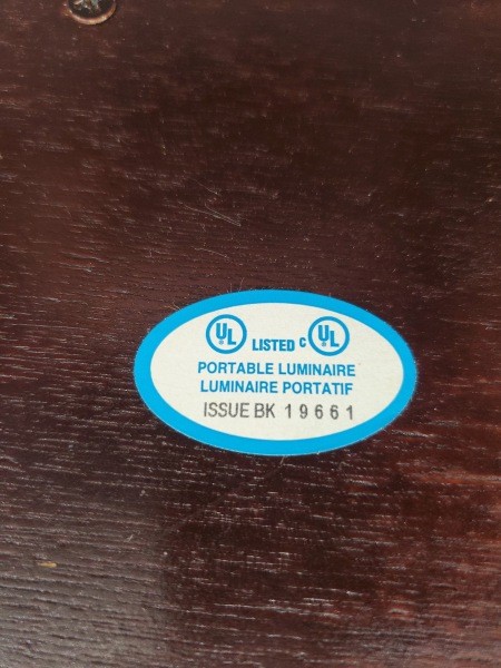 A sticker on the bottom of a lamp.