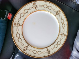 A china plate with a gold and ivory rim.