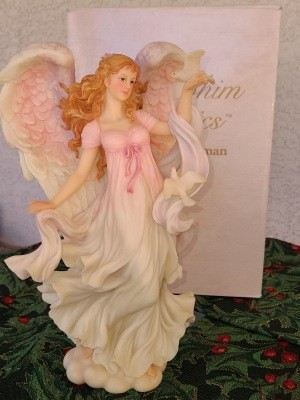 A figurine of an angel with a dress that shades from pink to white.
