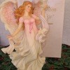 A figurine of an angel with a dress that shades from pink to white.