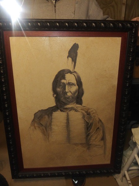 A old framed painting of a Native American man.