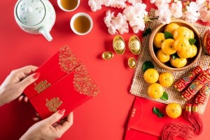 A woman holding lucky red envelopes for Chinese New Year.