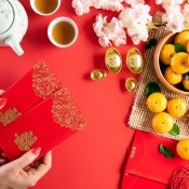 A woman holding lucky red envelopes for Chinese New Year.