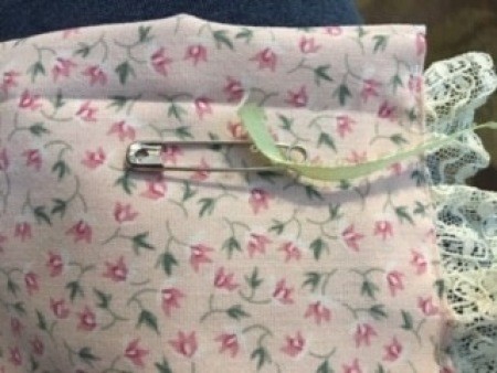 Adding ribbon to the bonnet.