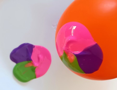 Dipping the balloon in the paint.