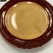 A cream colored plate with a dark brown rim.