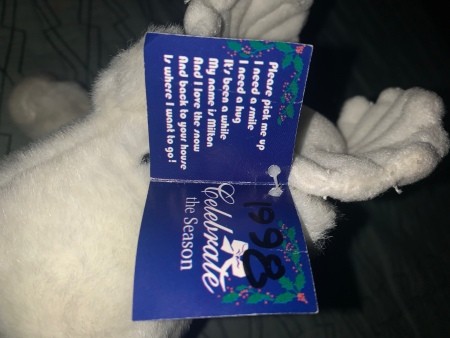 A white stuffed animal with a tag.