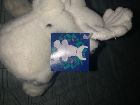 A white stuffed animal with a tag.