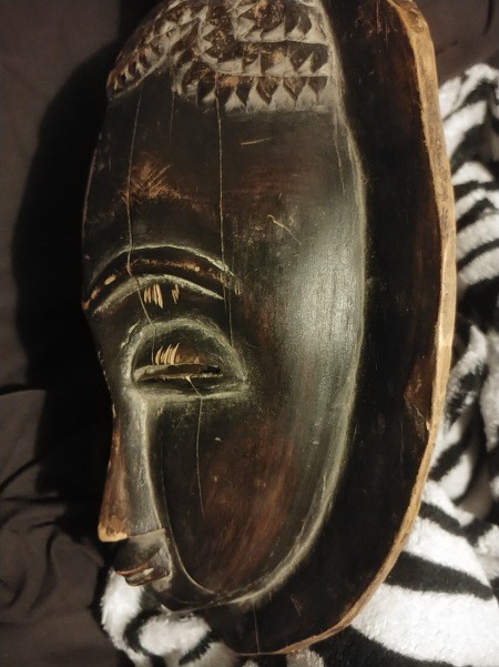 The side of a carved wooden mask.