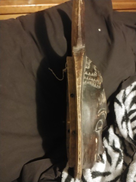 The side of a carved wooden mask.