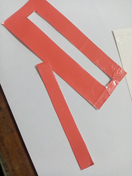 A piece of red cardstock with a cutout.