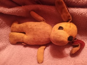 A small stuffed dog on a blanket.
