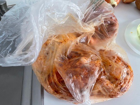 Seasoning the chicken in a plastic bag.