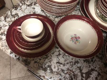 A collection of china with a red rim.