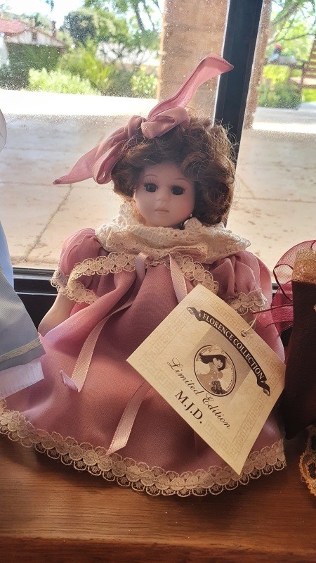 A porcelain doll in a pink dress.