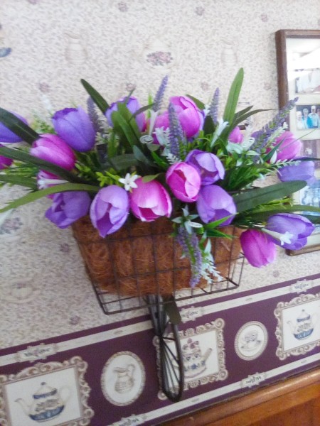 Purple and pink tulips in a bicycle basket decoration.