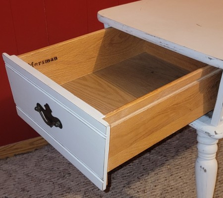 The open drawer on the side table.