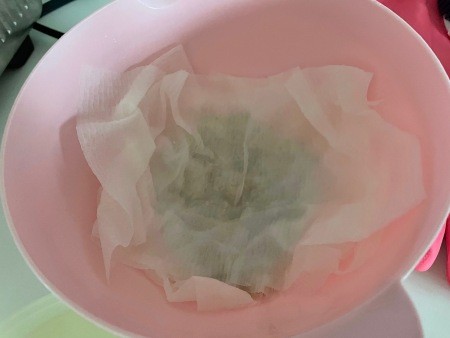 Placing a wet paper towel over the lentils.