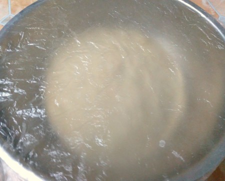 Covering the dough to allow rising.