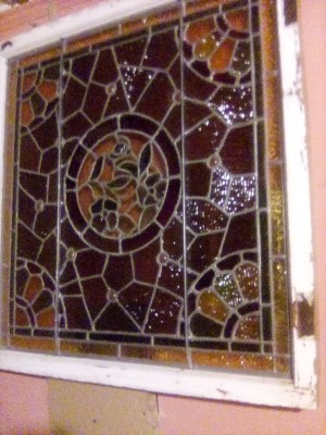 A stained glass window in a white window frame.