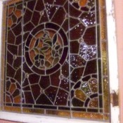 A stained glass window in a white window frame.