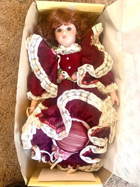 A porcelain doll in a box.
