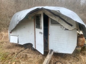 An old camper covered with a tarp.