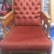 An old chair with reddish upholstery.