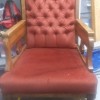 An old chair with reddish upholstery.