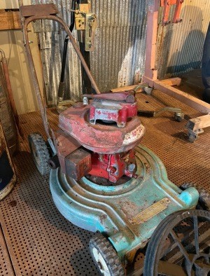 An old lawn mower in a garage.