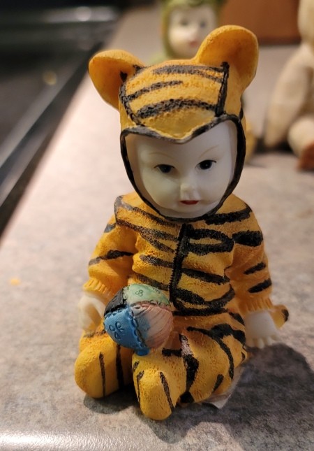 A figurine of a baby wearing a tiger costume.