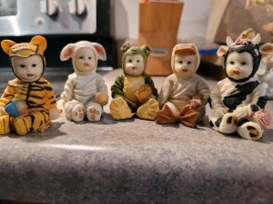 A collection of figurines of babies wearing animal costumes.