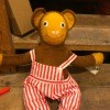 A stuffed monkey wearing striped overalls.