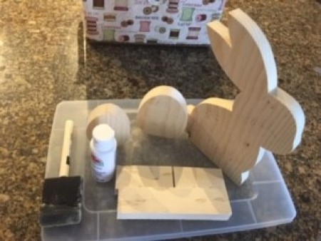 Supplies for wooden cutout bunnies and eggs.