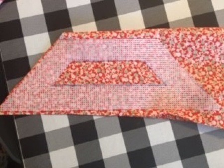 Cutting a rhomboid shape in the fabric.