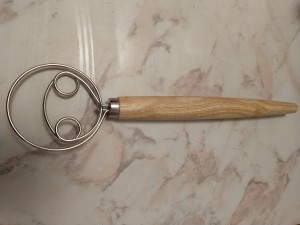 A metal and wood kitchen utensil.