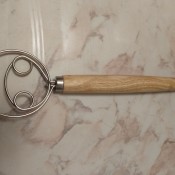 A metal and wood kitchen utensil.