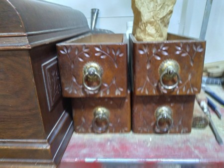 Wooden drawers in a sewing machine case.