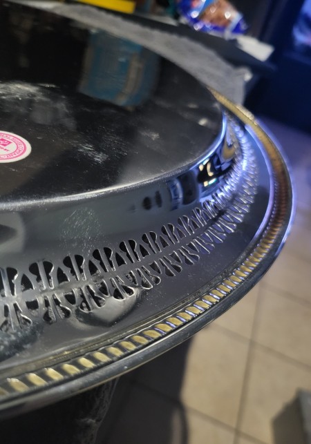 The side of a silver serving tray.