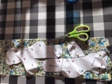 Cutting out bear shaped fabric.