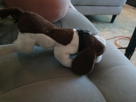 A brown and white stuffed dog, from the side.