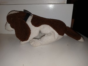 A brown and white stuffed dog, from the side.